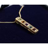 A 9CT GOLD PENDANT WITH PERIDOT, CITRINE, AMETHYST, BLUE TOPAZ AND GARNET, on a chain.