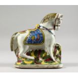 A TURKISH POTTERY HORSE, painted in brilliant colours. 7ins high.