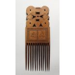 A TRIBAL CARVED WOOD COMB.