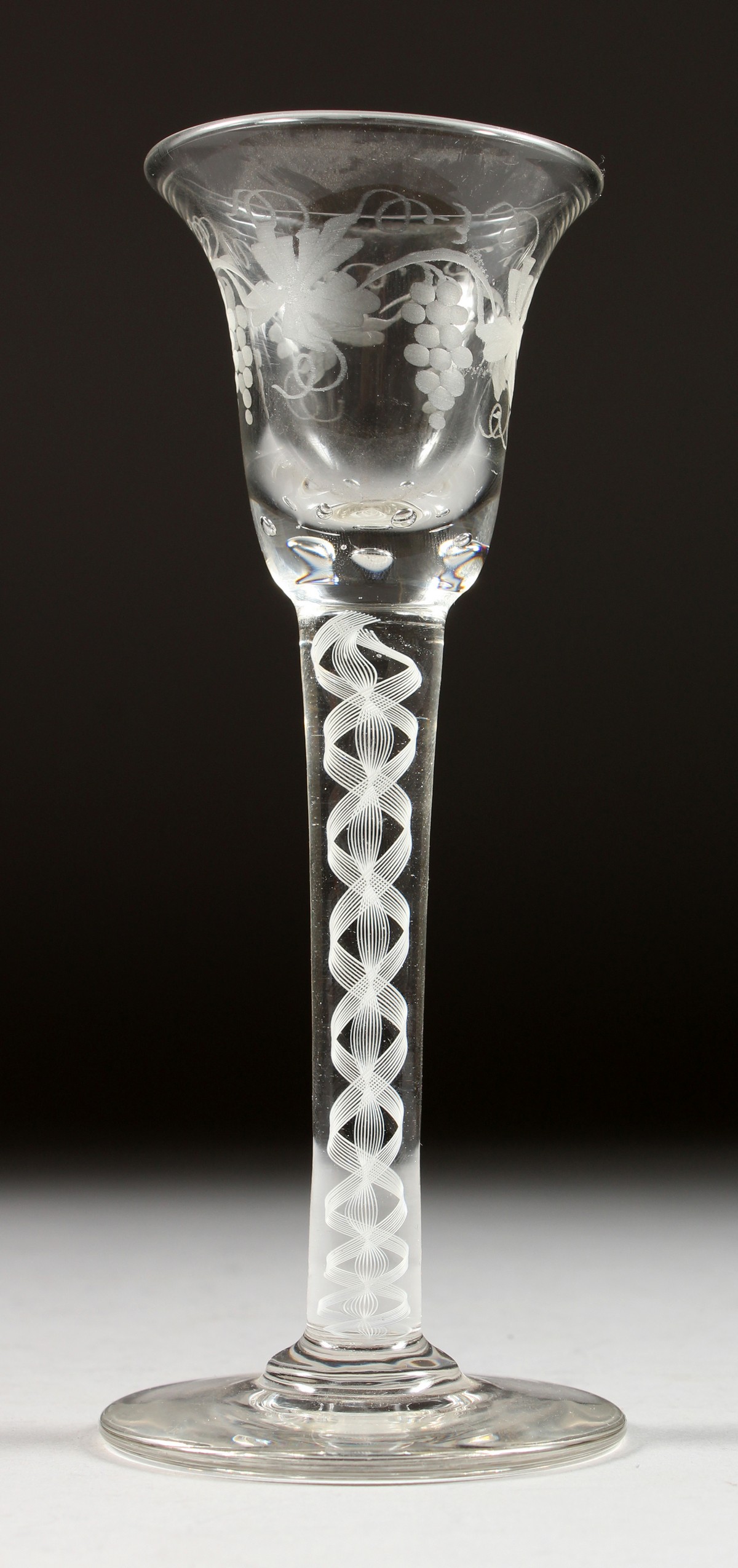 A GEORGIAN WINE GLASS, with inverted bell bowl etched with fruiting vines, with white air twist