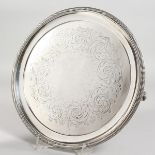 A VICTORIAN ENGRAVED CIRCULAR SALVER, with bead edge on three feet. 9.5ins diameter. Sheffield 1850.