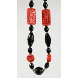 A CINNABAR LACQUER AND JET BEAD NECKLACE. 26ins long.