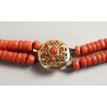 A TWO STRAND CORAL BEAD NECKLACE with 18ct gold clasp. 14ins long.