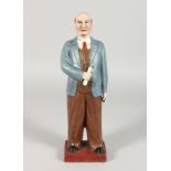 A RUSSIAN POTTERY STANDING FIGURE, holding a paper. 13ins high.
