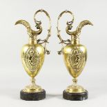 A GOOD PAIR OF 19TH CENTURY FRENCH ORMOLU EWERS, each with panels of cupids and mask spouts, on