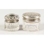 TWO SMALL CUT GLASS JARS with silver lids.