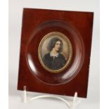 AN OVAL PORTRAIT MINIATURE OF A YOUNG LADY in a wooden frame. 2.25ins x 2ins. Signed.