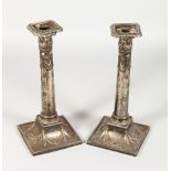 A PAIR OF ADAM DESIGN PLATE CANDLESTICKS with swags. 11ins high.