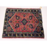 A SMALL PERSIAN RUG. mid 20th Century, red ground with stylized decoration. 3ft 3ins x 2ft 8ins.