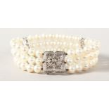 A GOOD WHITE GOLD TRIPLE ROW PEARL BRACELET with white gold and diamond clasp.