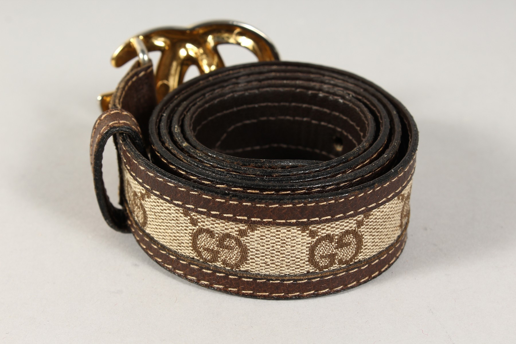 A BROWN LEATHER AND FABRIC GUCCI BELT with gilt GG. - Image 2 of 4