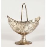 A VICTORIAN BOAT SHAPED SUGAR BASKET with repousse decoration, bead handle and edge. London 1868.