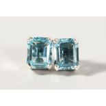 A PAIR OF SILVER EMERALD CUT BLUE TOPAZ EARRINGS.