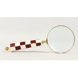 A MAGNIFYING GLASS with chequered handle.