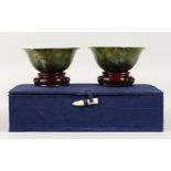 A PAIR OF SPINACH JADE CIRCULAR BOWLS. 4ins diameter, in a blue box.