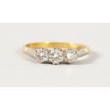 AN 18CT GOLD DIAMOND THREE STONE RING.