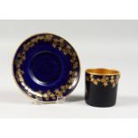 AN EARLY 20TH CENTURY CROWN DEVON BLUE AND GILT COFFEE CAN AND SAUCER.