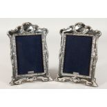 A PAIR OF SILVER PHOTOGRAPH FRAMES with butterflies and flowers. 8ins x 6ins.