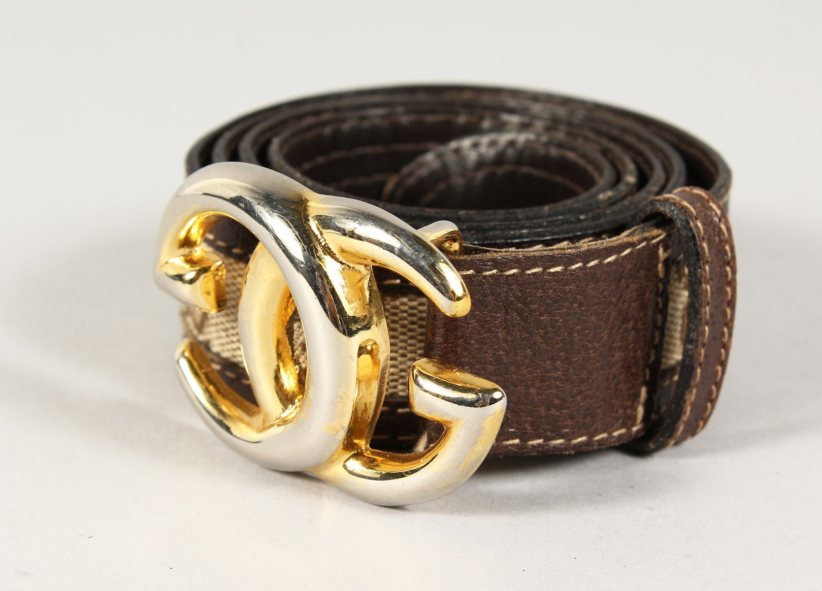 A BROWN LEATHER AND FABRIC GUCCI BELT with gilt GG.