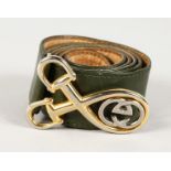 A GUCCI GREEN LEATHER BELT with gilt stirrups and GUCCI logo.