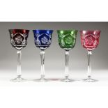 FOUR HARLEQUIN COLOURED CUT CRYSTAL HOCK GLASSES.