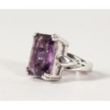 A SILVER LARGE EMERALD CUT AMETHYST RING.