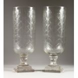 A LARGE PAIR OF CUT GLASS STORM LAMPS on square bases. 16ins high.