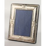 A HAMMERED PHOTOGRAPH FRAME with double shell border. 7ins x 5ins.