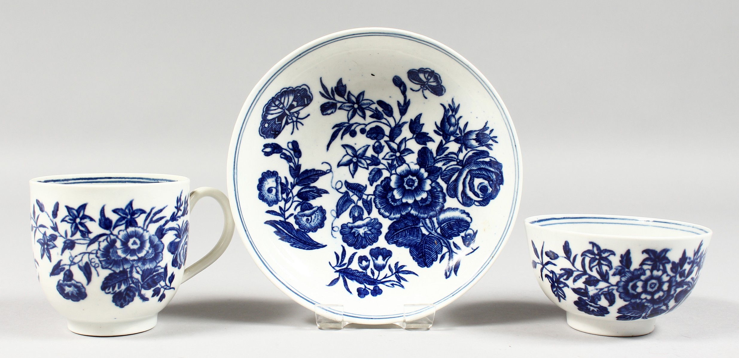 AN 18TH CENTURY WORCESTER COFFEE CUP, TEA BOWL AND SAUCER painted with the three flowers pattern.