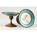 A GOOD SMALL PAIR OF SEVRES BLUE PORCELAIN TAZZAS with ormolu mounts painted with cupids. 4ins