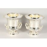 A GOOD PAIR OF SILVER PLATE TWO-HANDLED URN SHAPED WINE COOLERS with liners and rustic mask handles.
