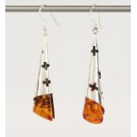 A PAIR OF SILVER AND AMBER DROP EARRINGS.