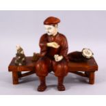 A JAPANESE MEIJI PERIOD CARVED IVORY AND WOOD OKIMONO OF A MONKEY TRAINER - seated upon a wooden