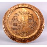 A LARGE EMBOSSED COPPERED JEWISH DISH, with two figures, with script on a board, with borders of