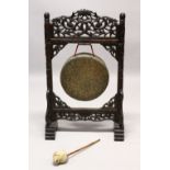 A 19TH CENTURY CARVED HARDWOOD DINNER GONG, the frame carved with bamboo, with the original