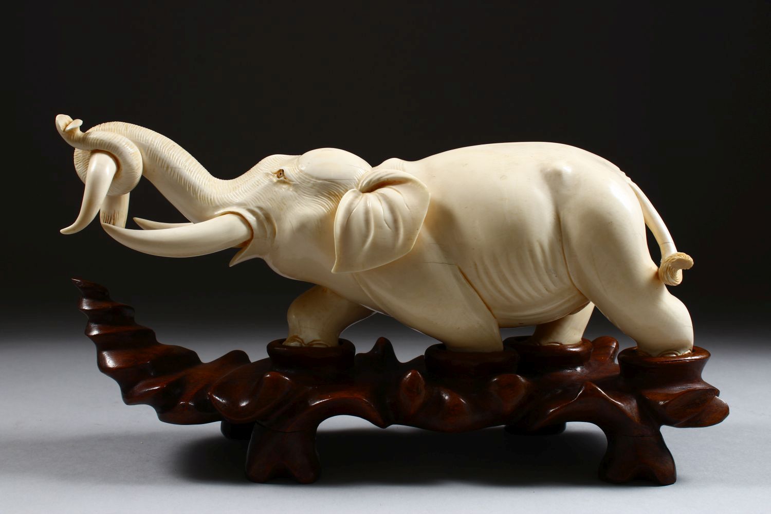 A 19TH CENTURY CHINESE CARVED IVORY FIGURE OF AN ELEPHANT, the elephant holding on to the horn of - Image 2 of 9