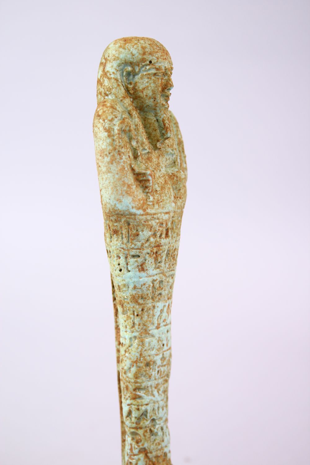 A CARVED POTTERY EGYPTIAN SHABTI, stoof upon a wooden base, 19cm high. - Image 3 of 4