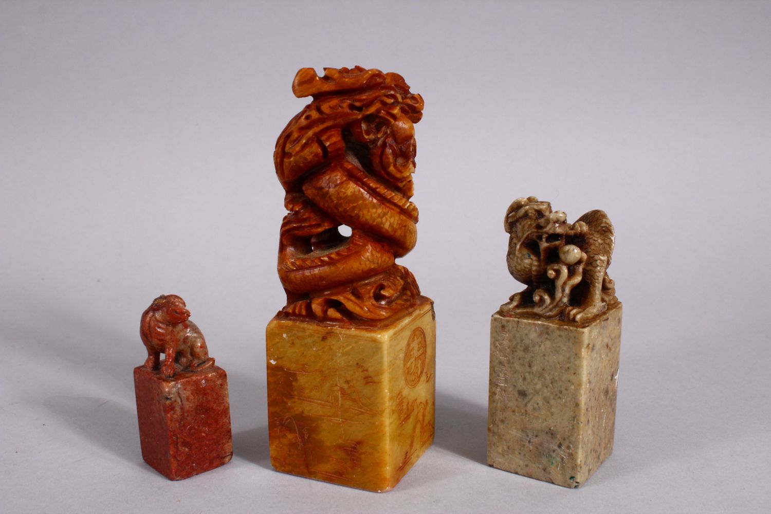 THREE CHINESE CARVED SOAPSTONE SEALS, each carved with dragons and lion dogs, two bases carved - Image 2 of 4