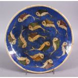 AN ISLAMIC QAJAR BLUE & WHITE POTTERY FISH PLATE, decorated with swimming fish, 25cm