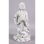 A CHINESE 19TH / 20TH CENTURY BLANC DE CHINE PORCELAIN FIGURE OF ROHAN - in a stood position holding