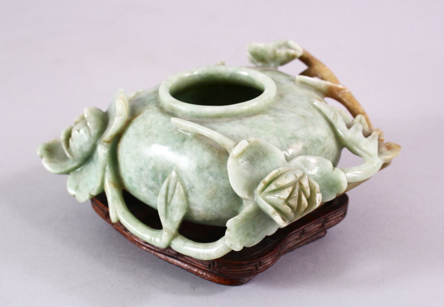 A CHINESE CARVED JADE FLORAL CARVED BRUSH WASH, on a fitted wooden base, 13 cm diameter,