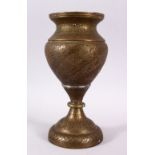 A 19TH CENTURY ISLAMIC QAJAR OPENWORK BRASS VASE, carved with formal scrolling foliage, 27cm high