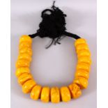 A LARGE 19TH CENTURY ISLAMIC PRESSED AMBER BEAD NECKLACE, with 20 spherical pressed amber beads on a