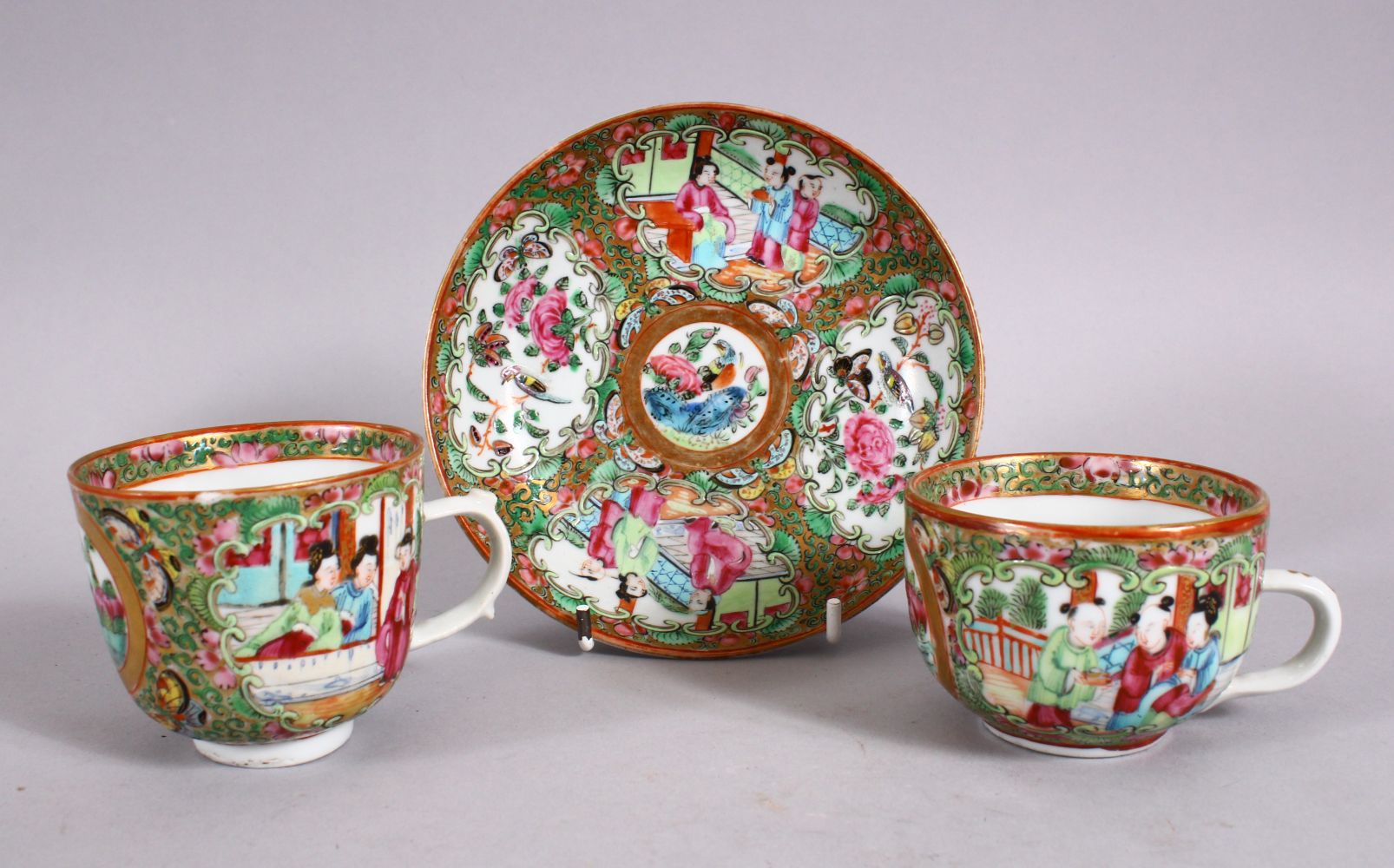 A 19TH CENTURY CHINESE FAMILLE ROSE CANTON CUPS & SAUCER, decorated with panels of birds and flora &