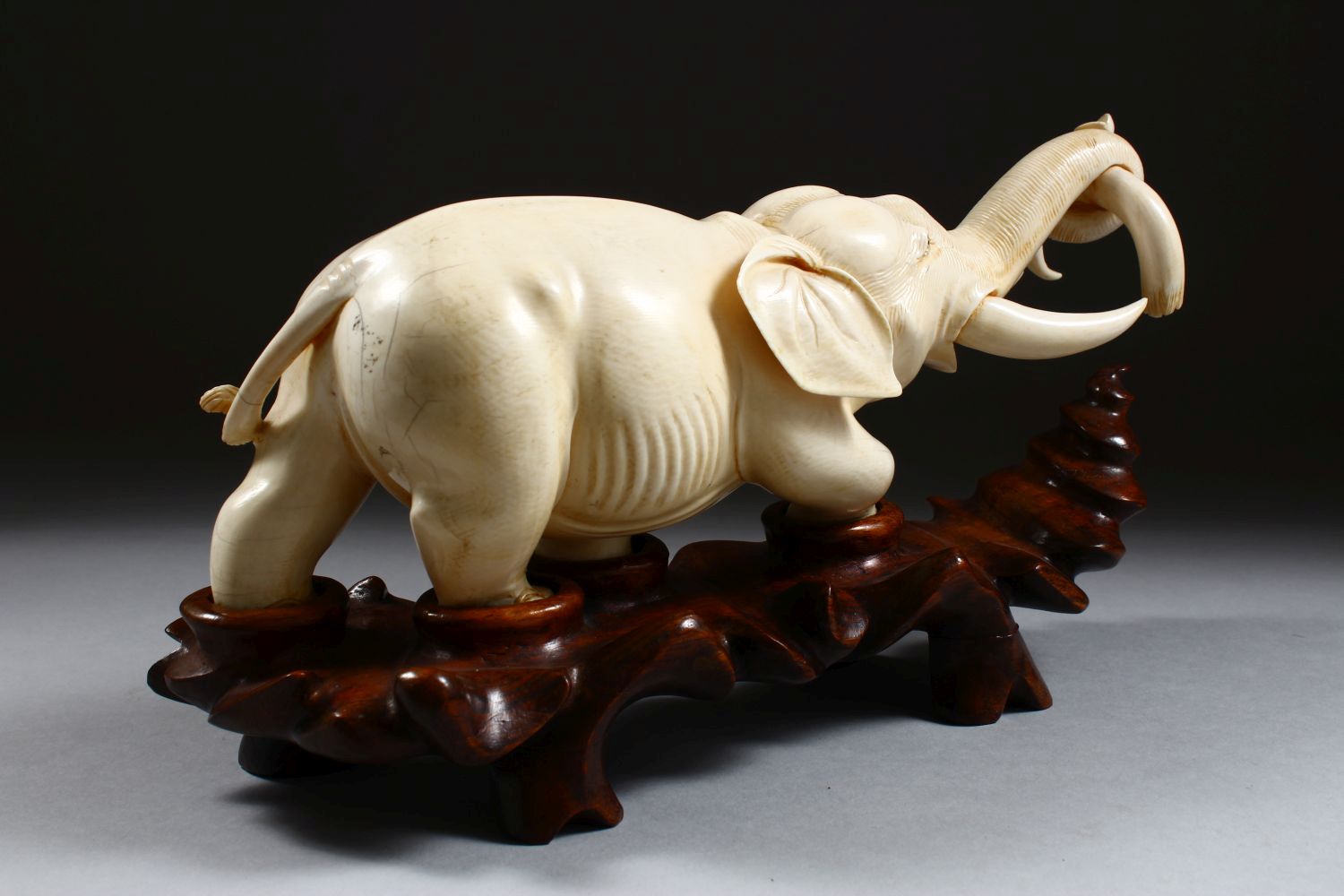 A 19TH CENTURY CHINESE CARVED IVORY FIGURE OF AN ELEPHANT, the elephant holding on to the horn of - Image 3 of 9