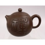 A GOOD CHINESE YIXING CLAY TEAPOT, with carved symbol, base with impressed mark, 10cm wide.