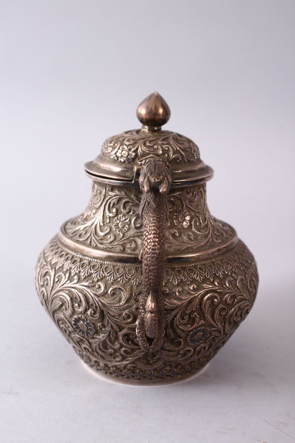 A GOOD 19TH CENTURY TURKISH SOLID SILVER TEAPOT carved with formal foliage and a dog style handle, - Image 4 of 10