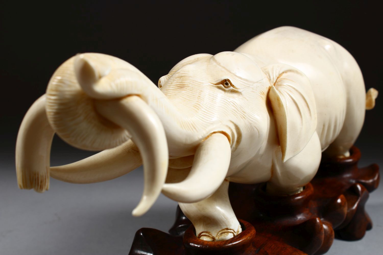 A 19TH CENTURY CHINESE CARVED IVORY FIGURE OF AN ELEPHANT, the elephant holding on to the horn of - Image 7 of 9