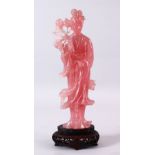 A LARGE CHINESE CARVED ROSE QUARTZ FIGURE OF GUANYIN, stood holding a bouquet of flora, on its
