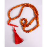 A CHINESE QING DYNASTY CARVED AMBER PRAYER BEADS / ROSARY NECKLACE, comprising 99 beads, 3 spacers